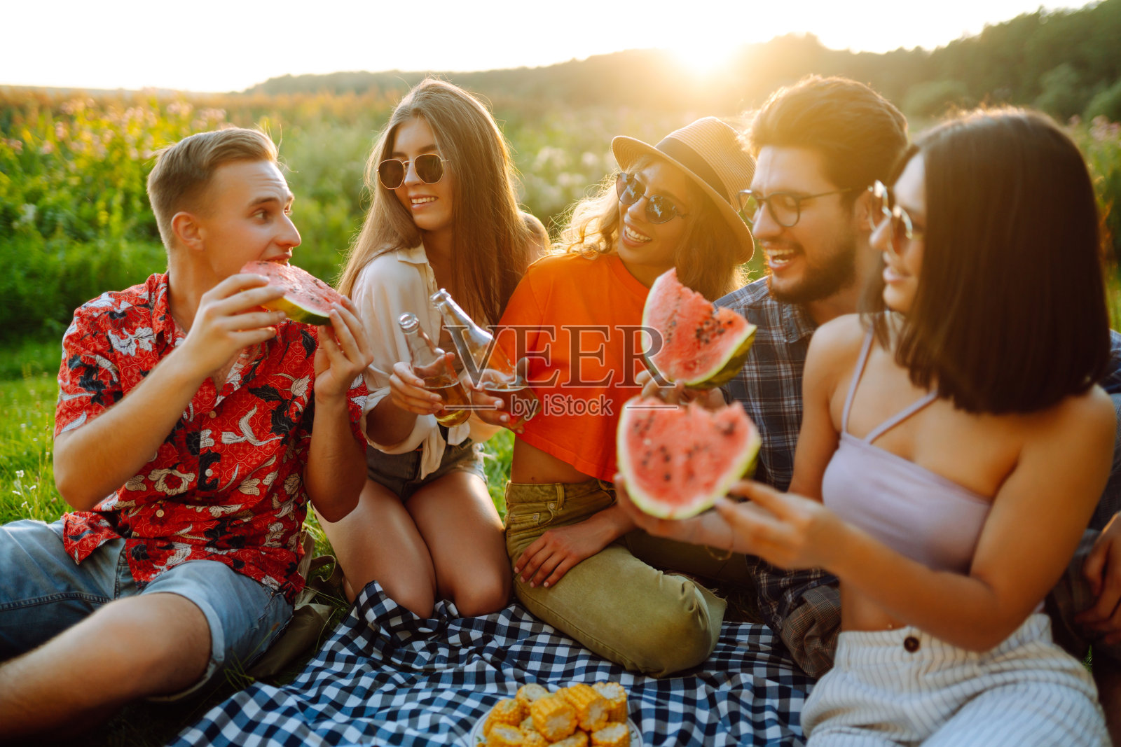 一群快乐的朋友在大自然中野餐。照片摄影图片