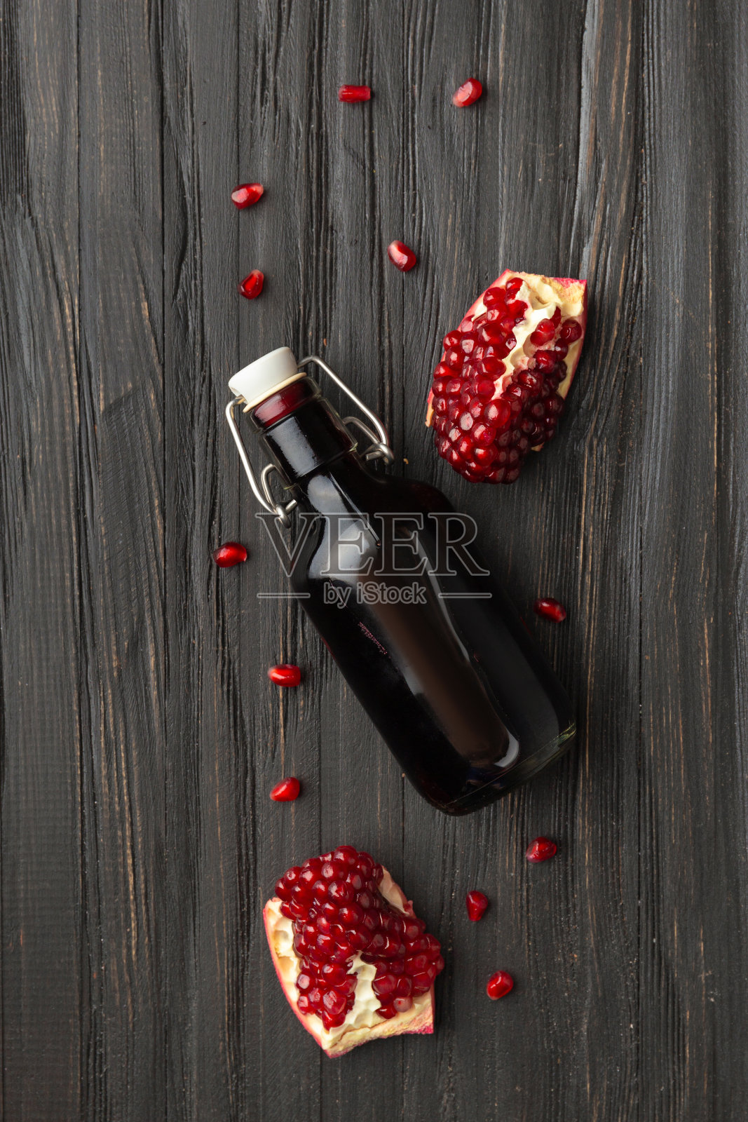 石榴，散落的种子和石榴汁在一个木制的背景。照片摄影图片