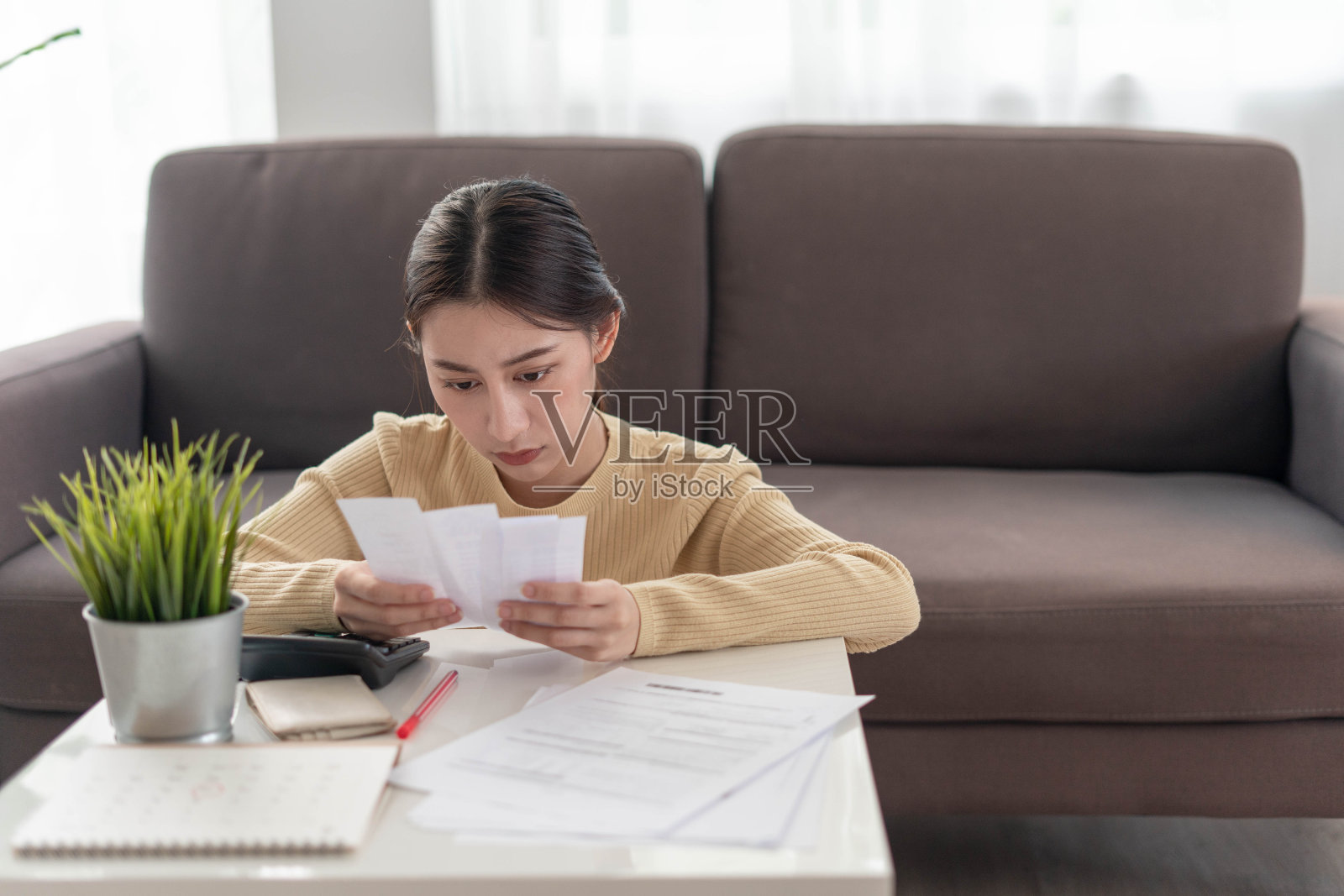 女性头痛和压力每月账单和信用卡债务。照片摄影图片