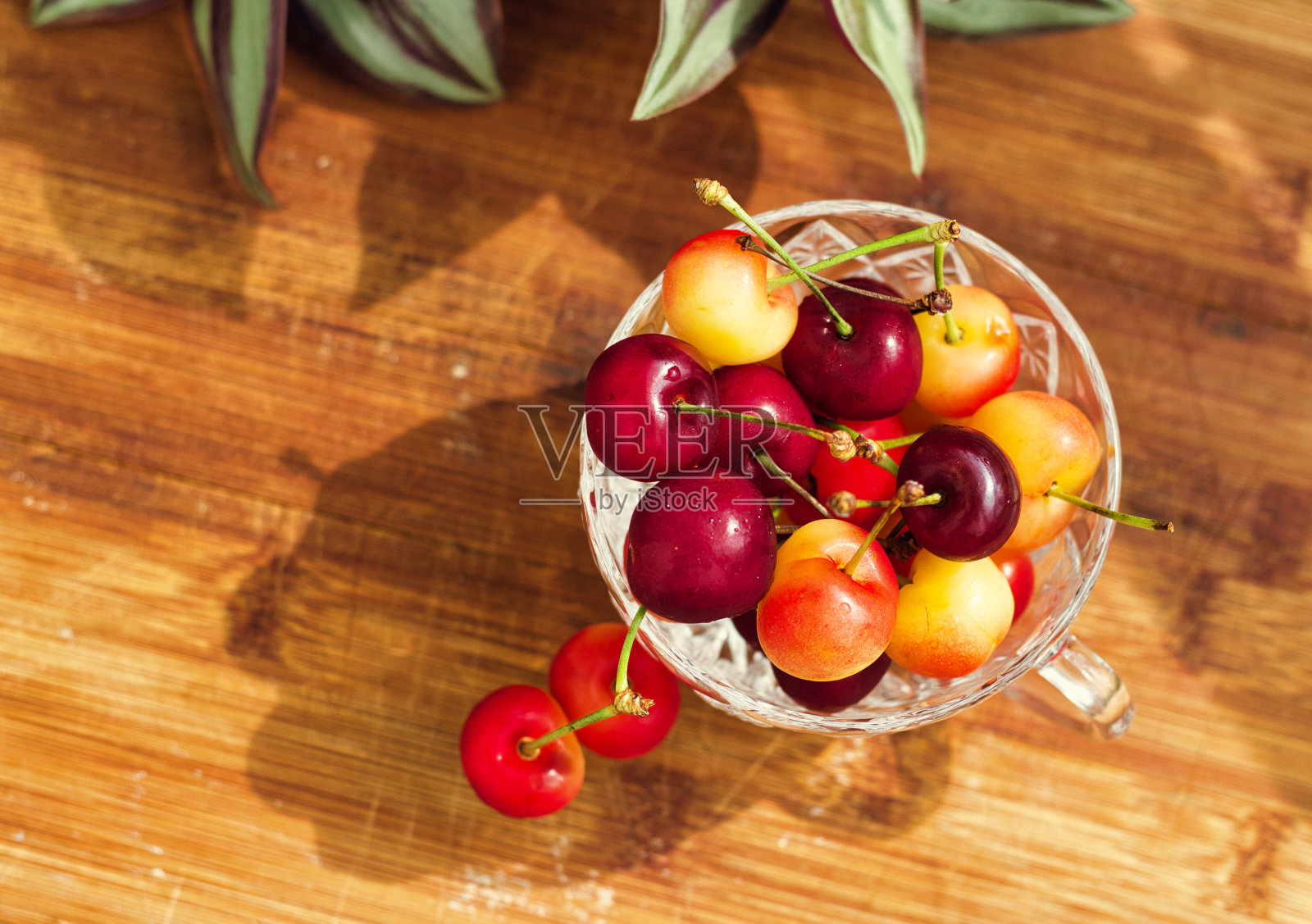 水晶碗里的新鲜樱桃。照片摄影图片