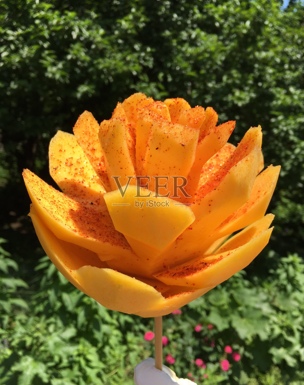 芒果切得像花一样，从街边的食品摊贩那里买来的照片摄影图片