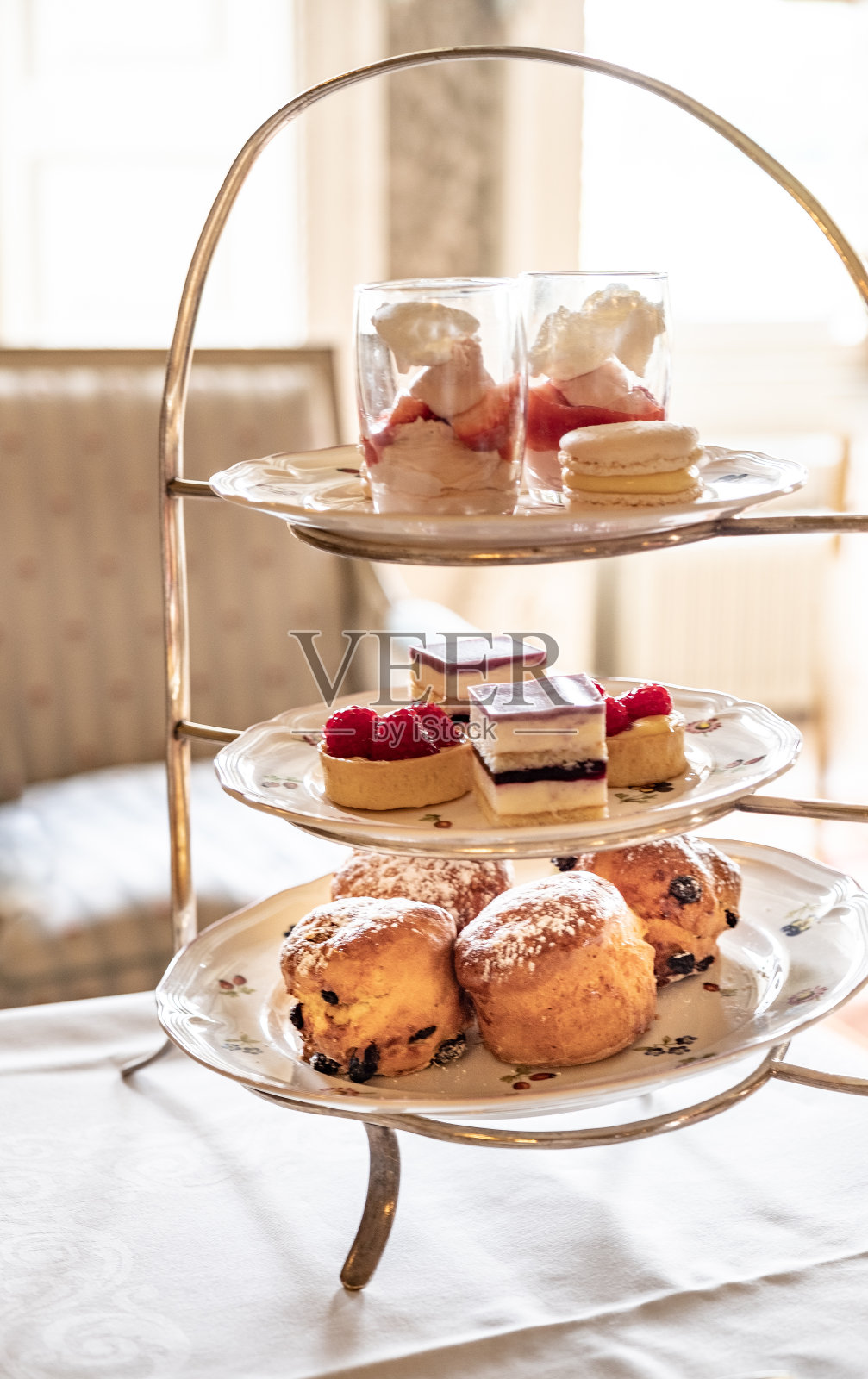 一个蛋糕摊，摆满了美味的烤饼、蛋糕和其他美味的食物，这是一个庄严的英国下午的一部分。照片摄影图片