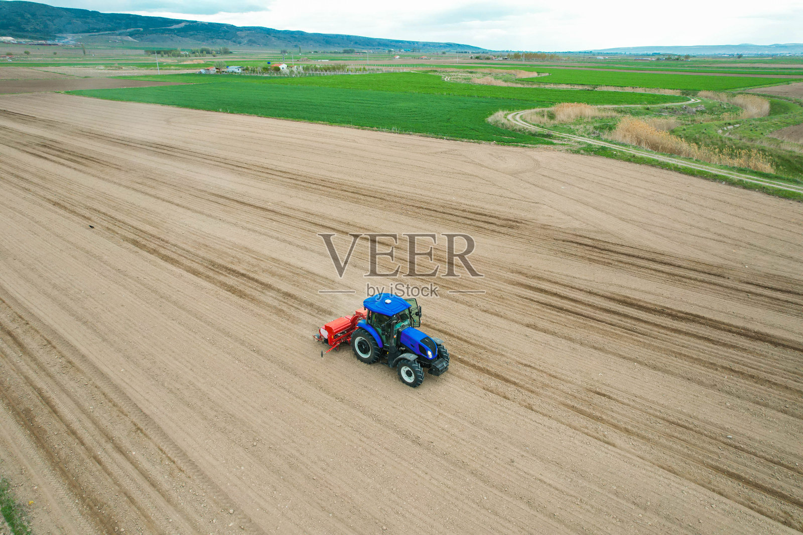 无人机俯视图的农民种植玉米与拖拉机和播种机的田地照片摄影图片