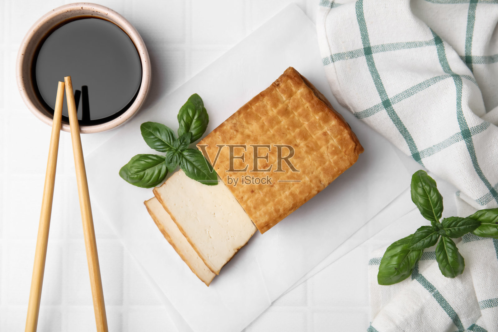 美味的烟熏豆腐，酱油和罗勒，平铺在平铺的桌子上照片摄影图片