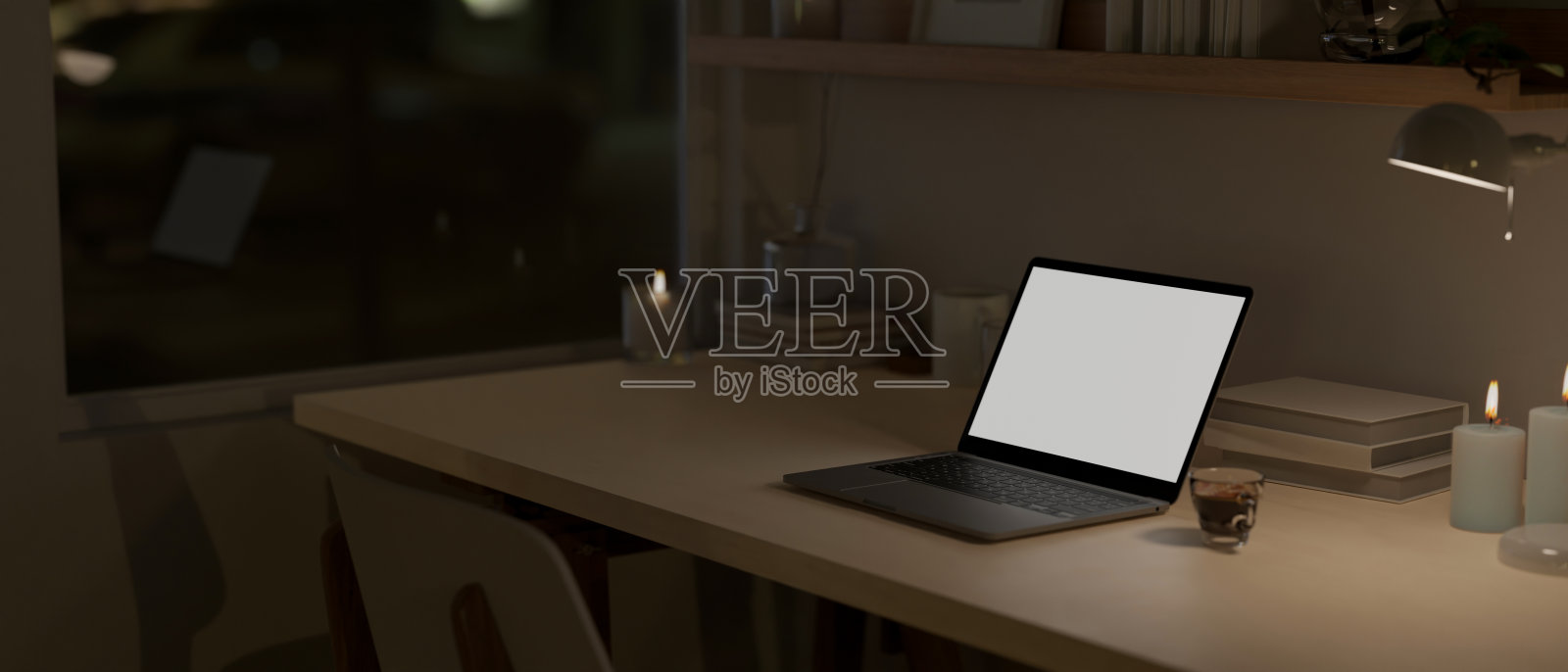 夜晚的家庭工作空间，在黑暗的房间里，笔记本电脑模型放在木桌上。照片摄影图片