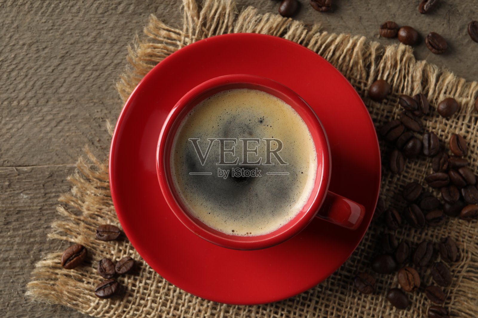 木桌上的一杯芳香的咖啡和豆子，俯视图照片摄影图片