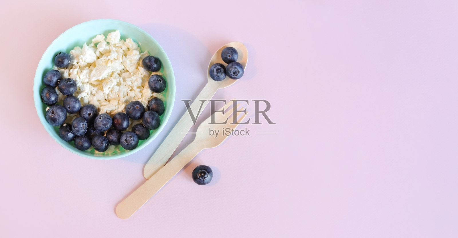 浅粉色背景的白干酪配蓝莓照片摄影图片