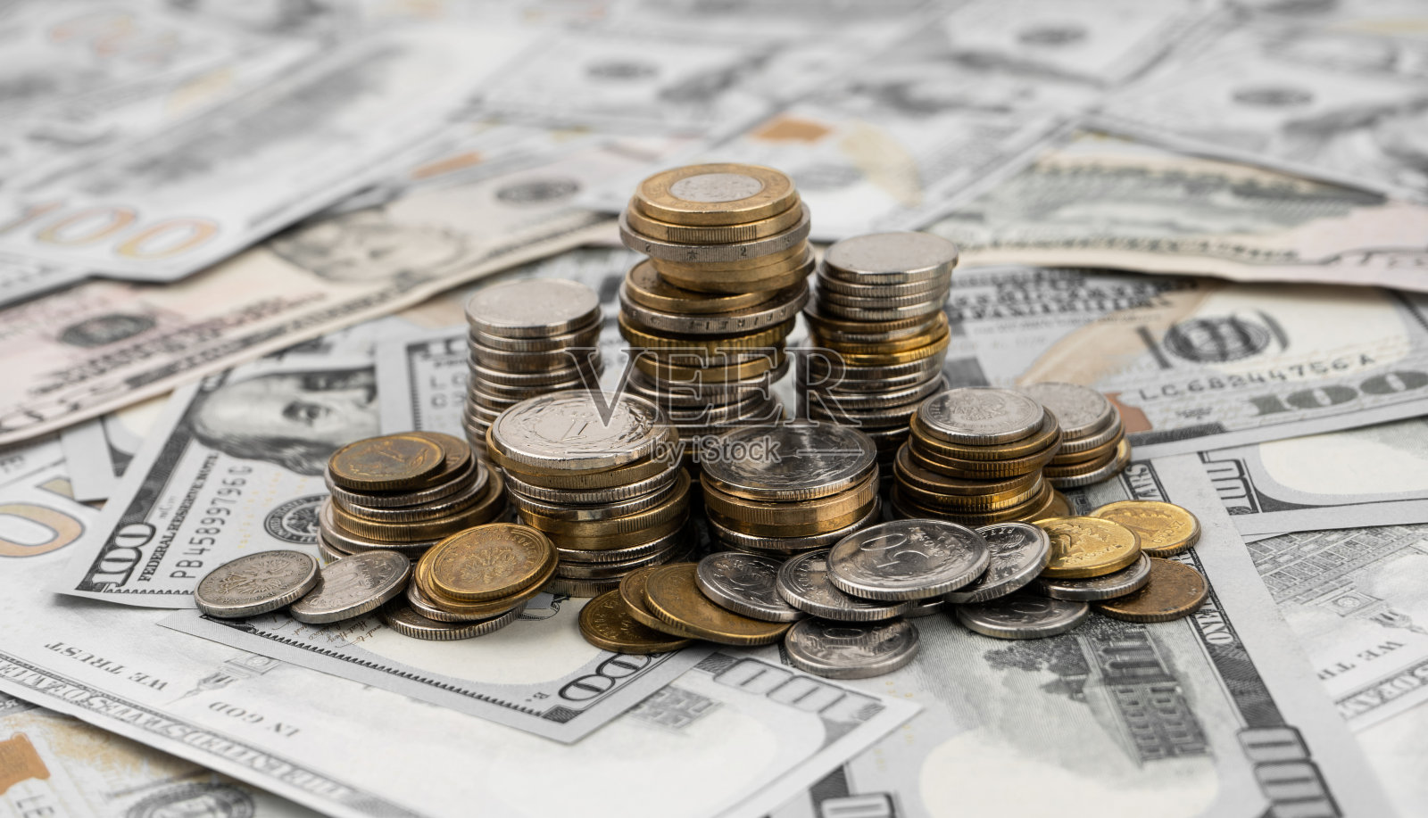 桌子上一美元钞票上的一堆堆金币。照片摄影图片