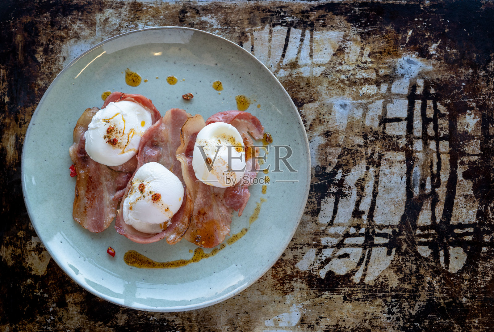 荷包蛋和辣酱熏肉放在盘子里，背景是乡村风光。照片摄影图片