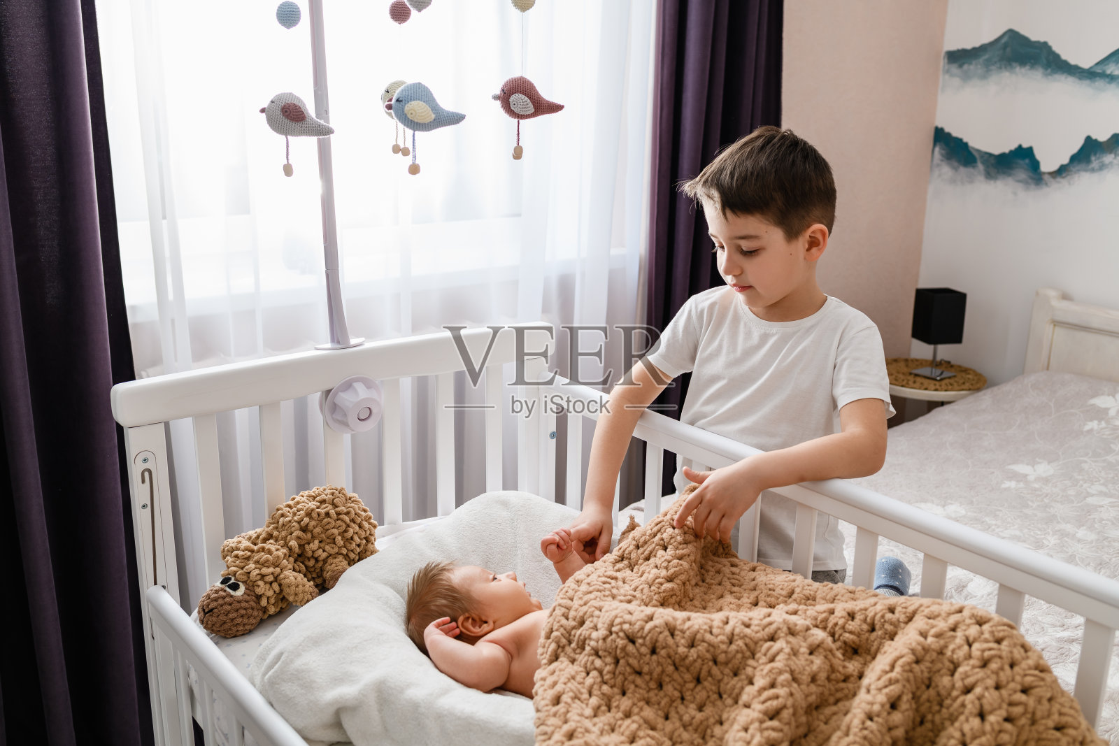 哥哥握着新生婴儿的手照片摄影图片