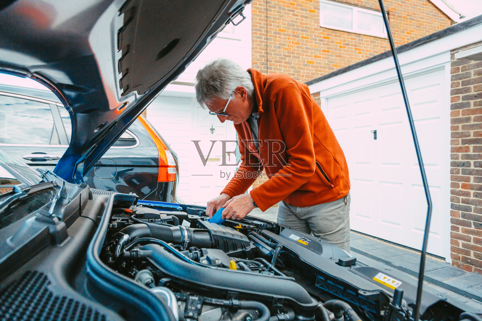 一个人在家里检查他的汽车引擎照片摄影图片
