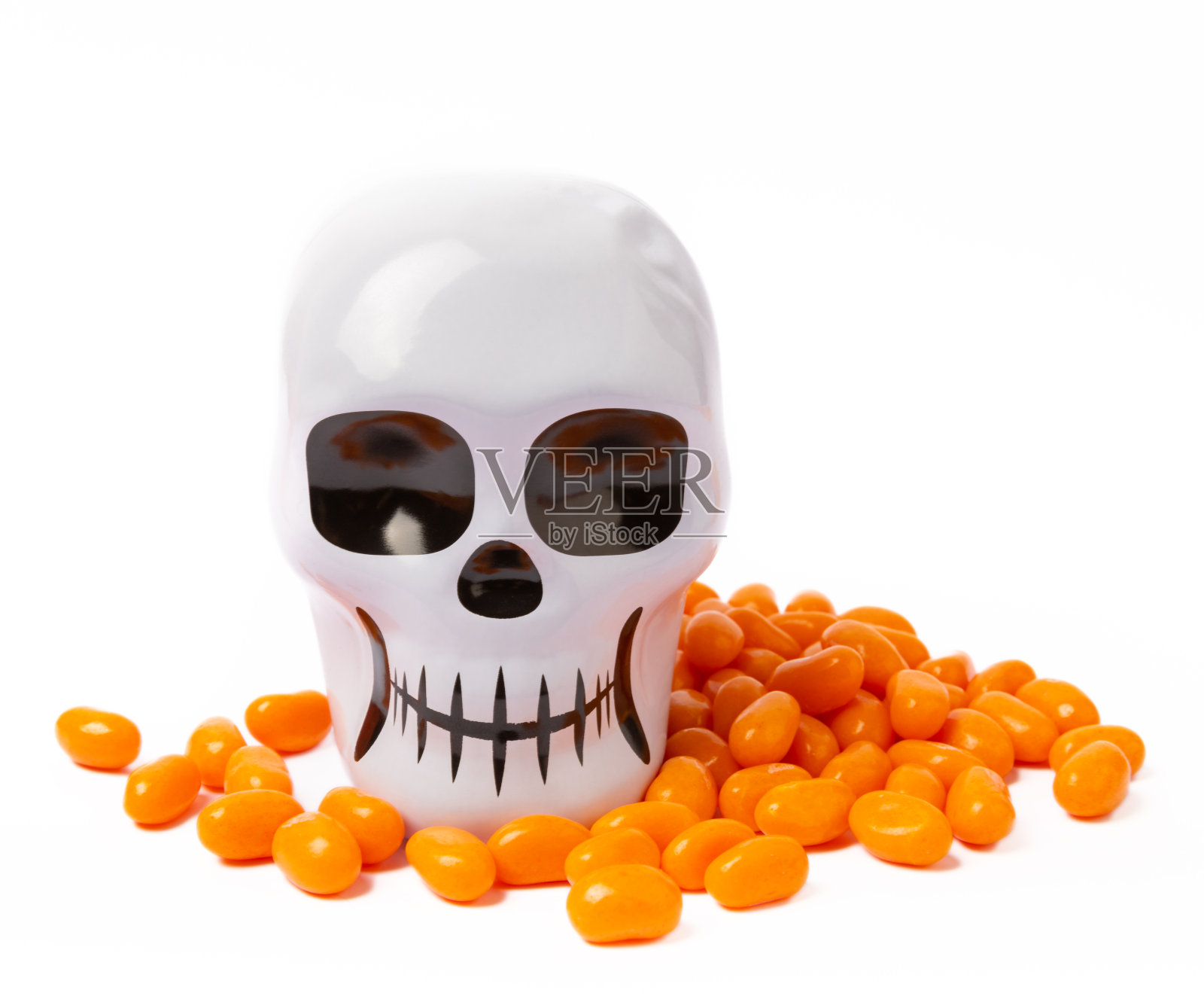 在白色背景上孤立的糖果玉米。万圣节的概念。一桶万圣节南瓜南瓜灯和玉米糖庆祝万圣节。南瓜脸上带着可怕的微笑。糖果桶。照片摄影图片