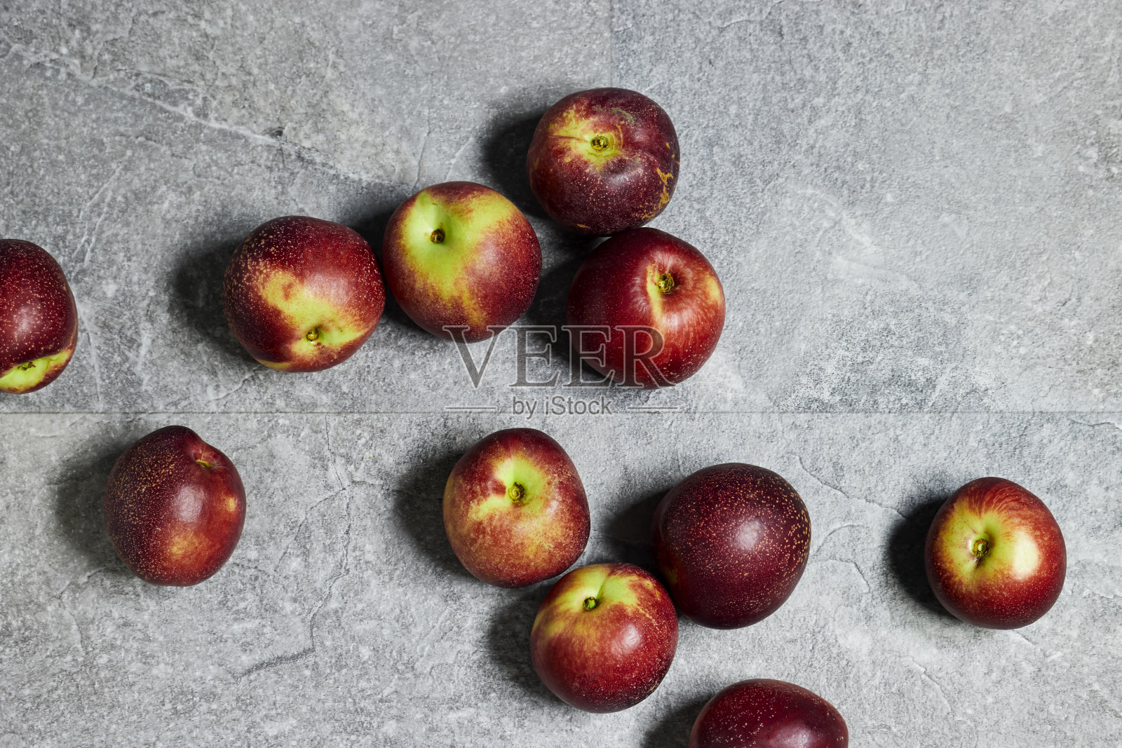 新鲜甜美的成熟桃子在灰色杂色背景照片摄影图片