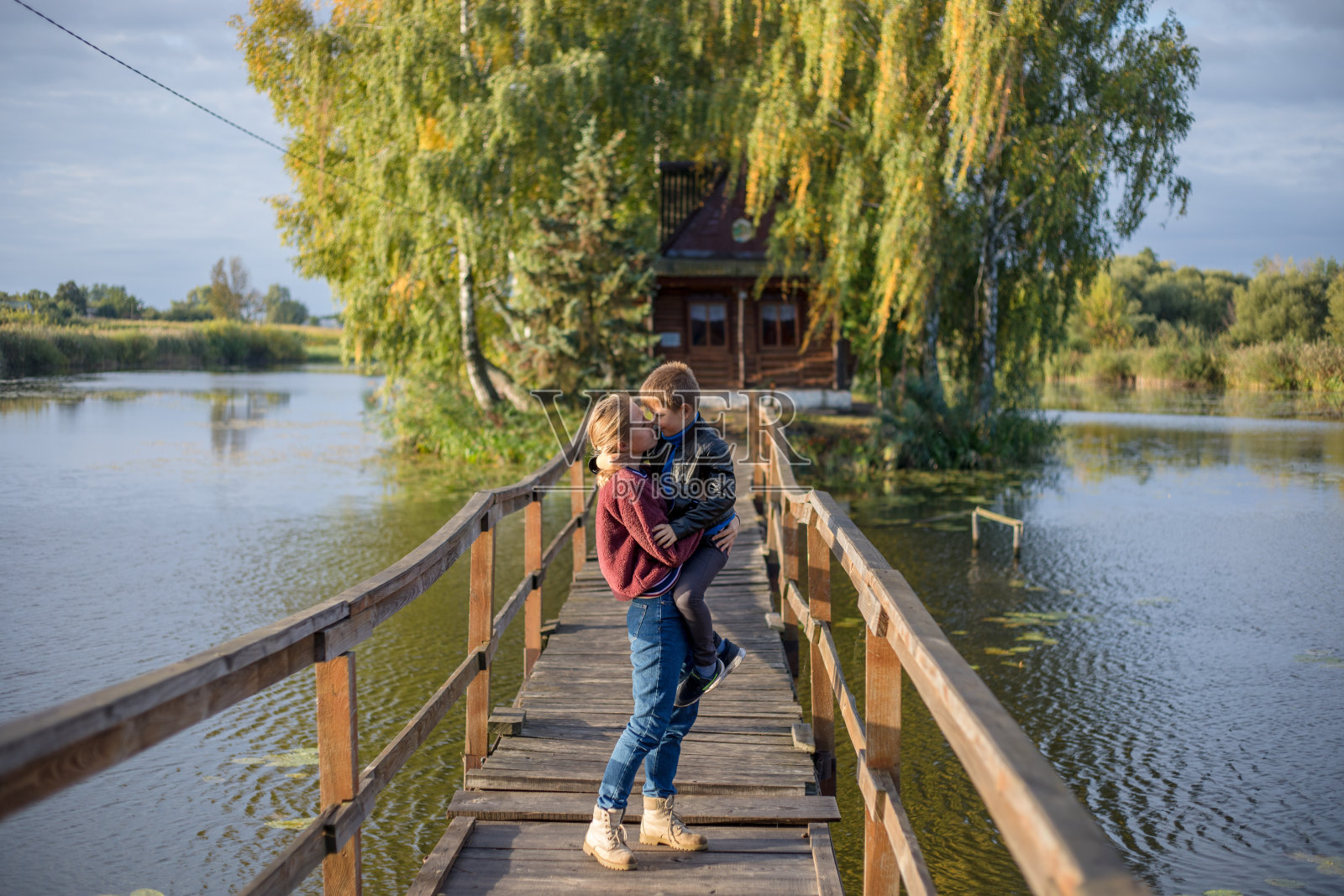 母亲和快乐的儿子问候，骄傲的和拥抱在一起。妈妈和可爱的孩子在户外玩耍照片摄影图片