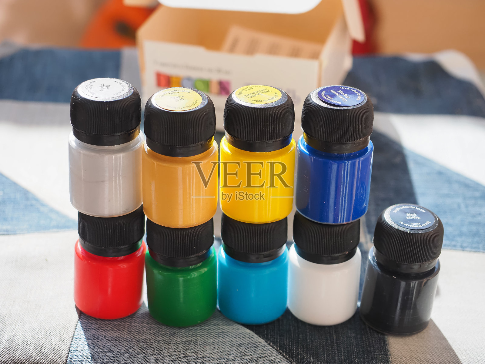 装有彩色丙烯酸颜料的罐子，用于在织物上作画照片摄影图片