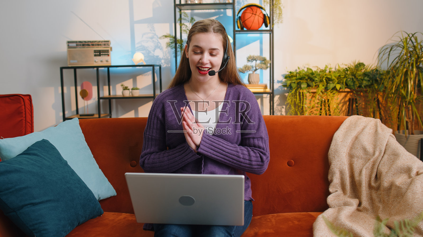 年轻女子戴着耳机，支持服务接线员热线与客户或同事交谈照片摄影图片
