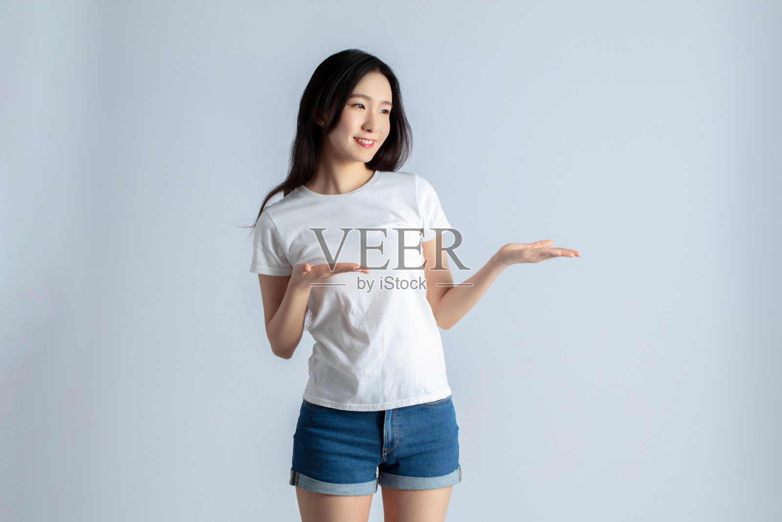 穿着白衬衫和牛仔短裤的年轻女子照片摄影图片