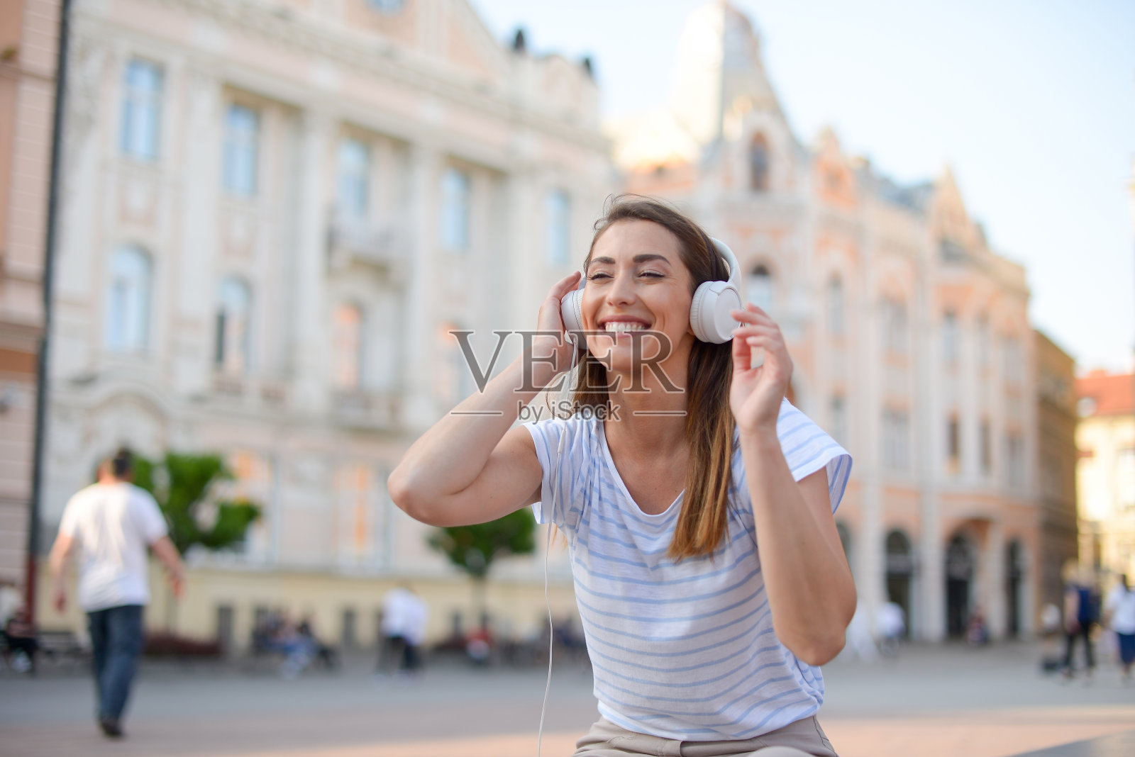 一个美丽的年轻女子享受户外和听音乐的肖像照片摄影图片