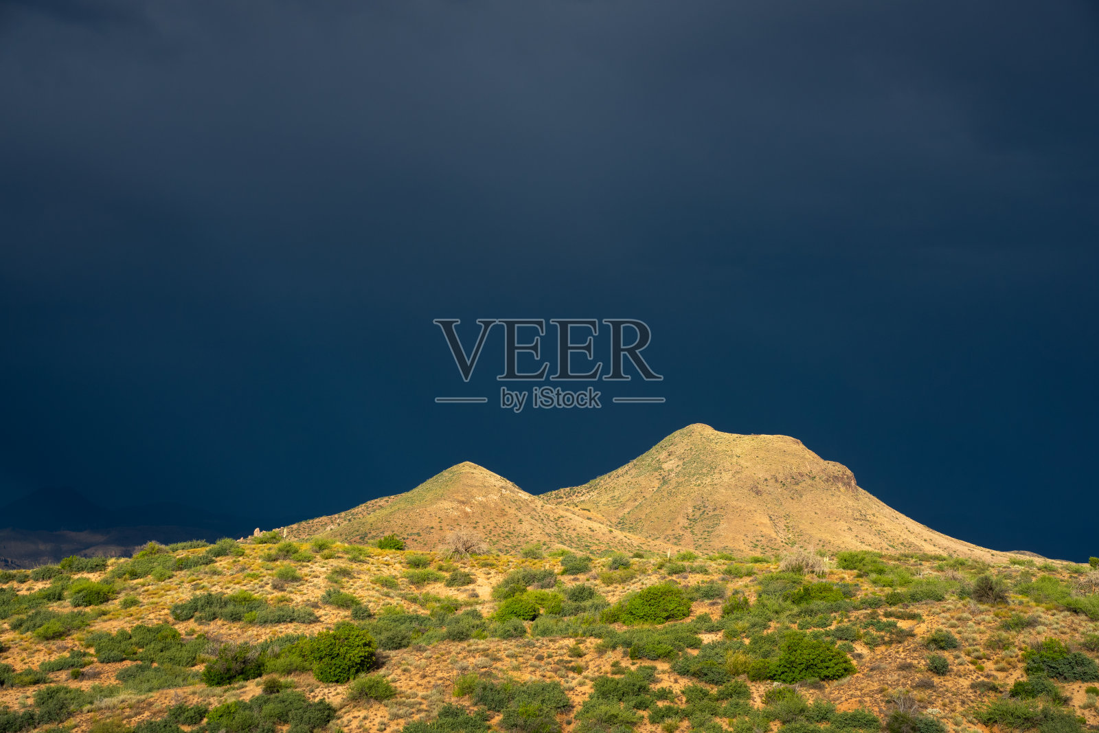 五月的季风为沙漠高地提供了戏剧性的照明，远处隐约可见季风雷暴照片摄影图片