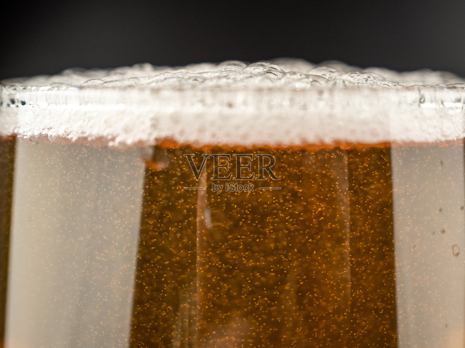 一杯冰啤酒，背景是黑色的。照片摄影图片