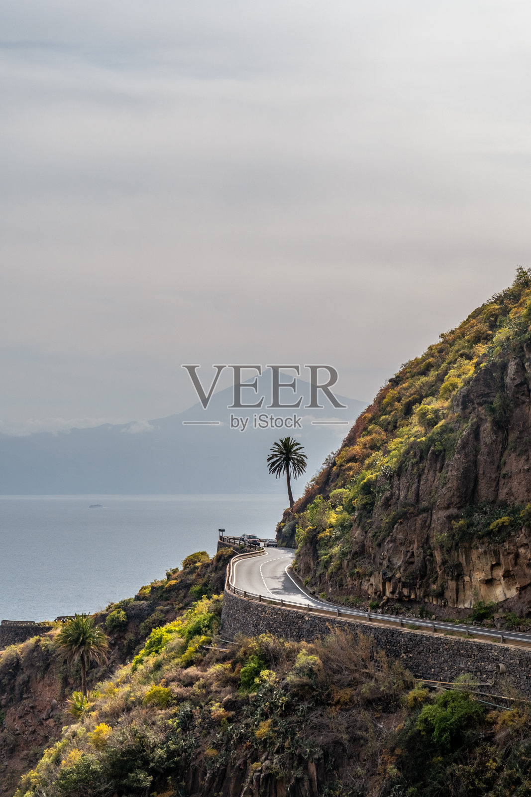 加那利群岛，戈梅拉北部阿古洛村的道路，背景是一棵棕榈树和特内里费岛照片摄影图片