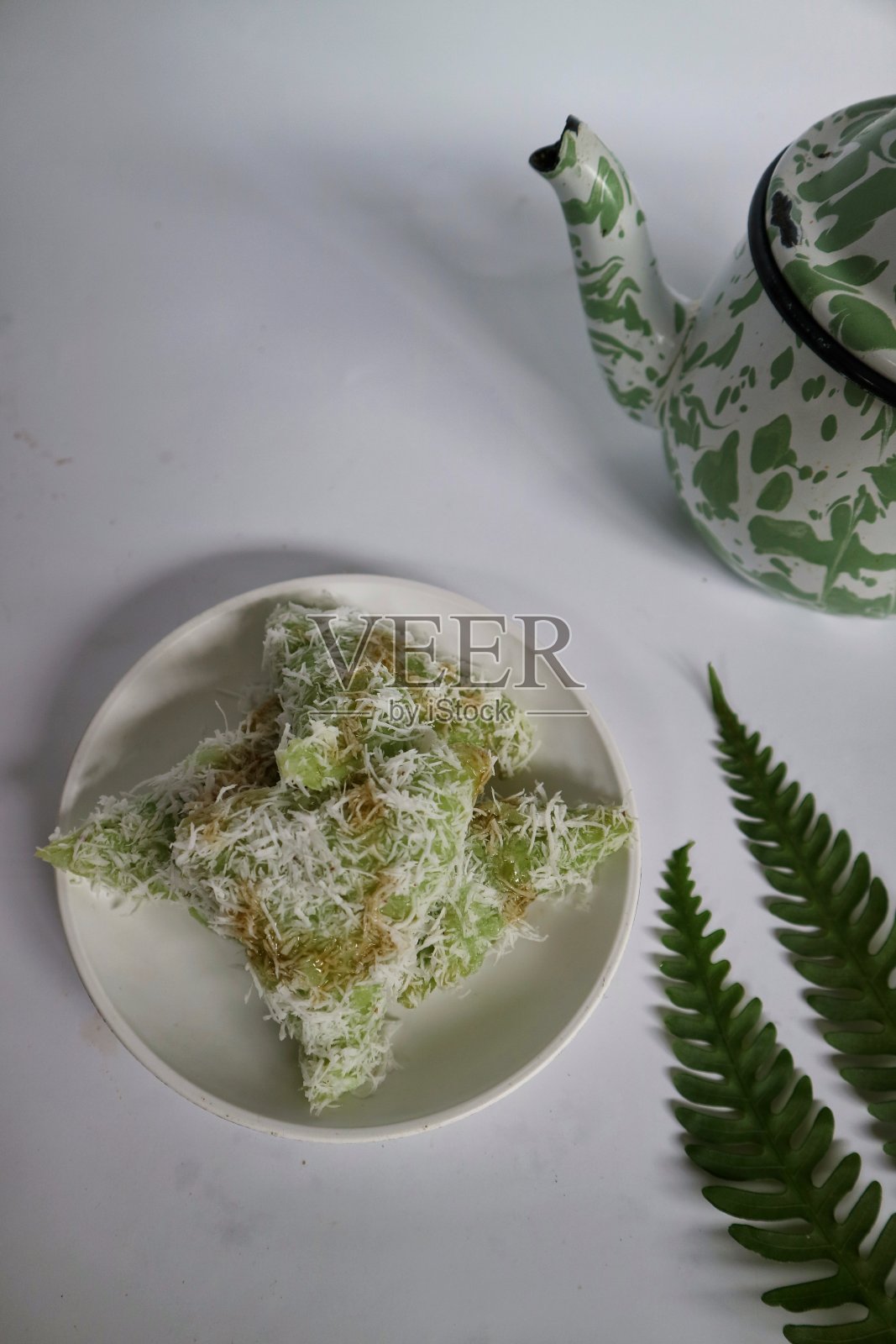 印尼红糖酱Lupis。Kue lupis是一种传统的印尼甜糯米。由糯米和磨碎的椰子制成，配上棕榈糖浆。照片摄影图片