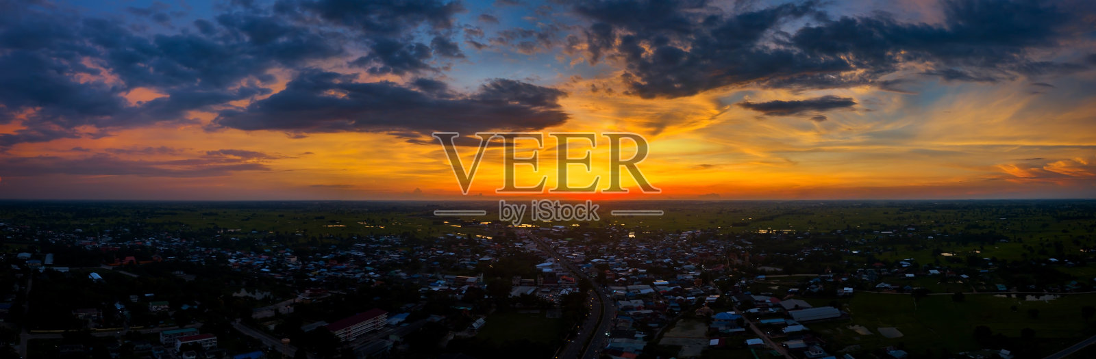 全景俯视图无人机在泰国村庄上空拍摄的航拍照片。顶视图美丽的日落与戏剧性的天空云。日出，乌云笼罩稻田。照片摄影图片