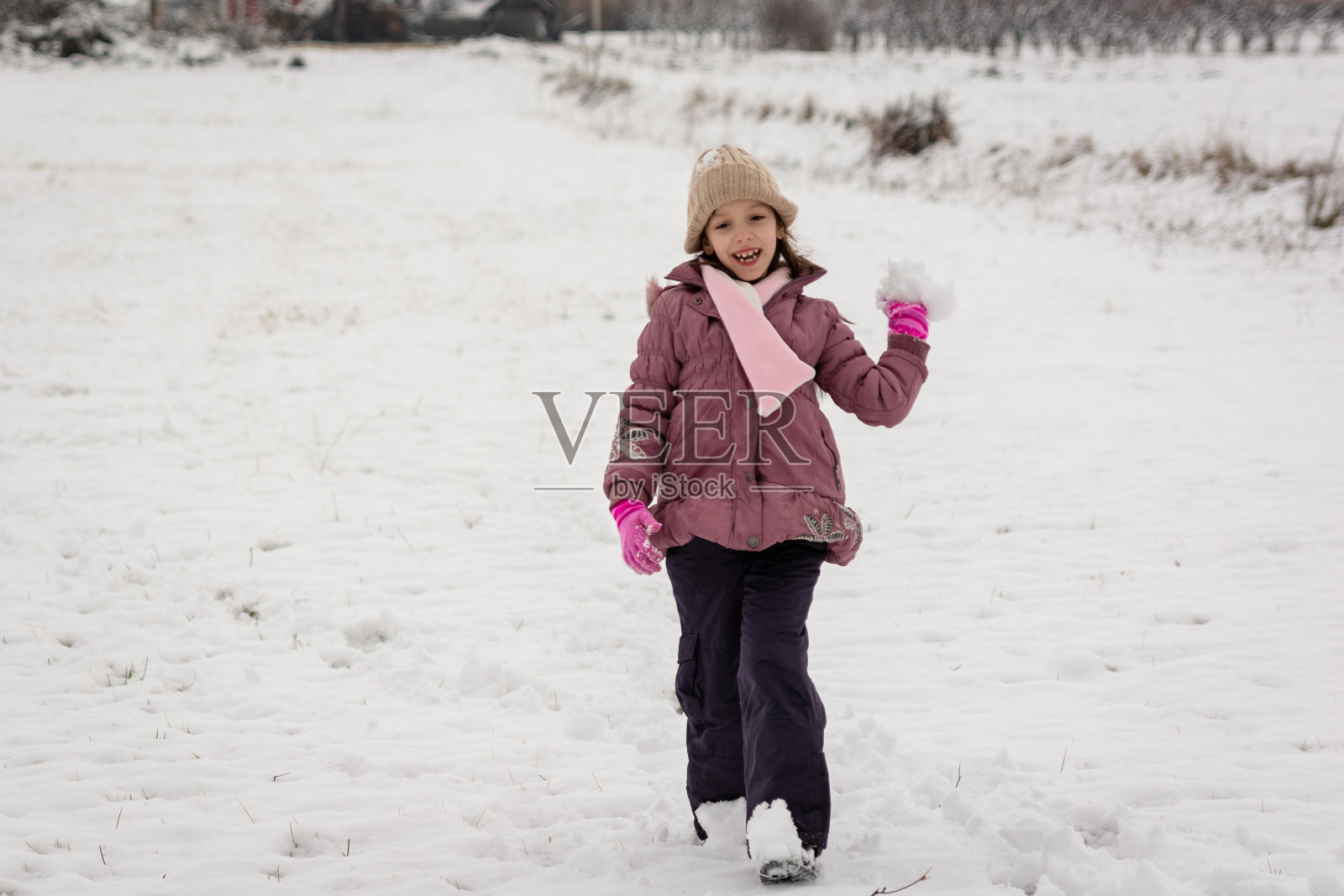快乐的小女孩在冬日的草地上玩白雪照片摄影图片