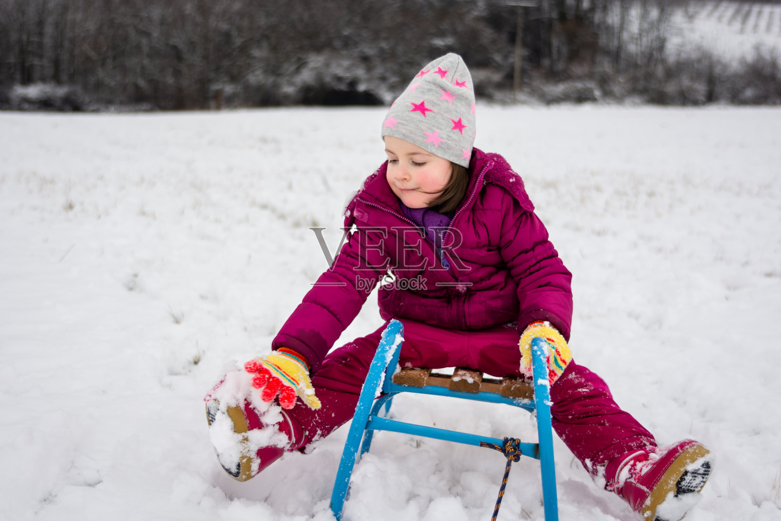 冬日草地上快乐的孩子在雪橇上照片摄影图片
