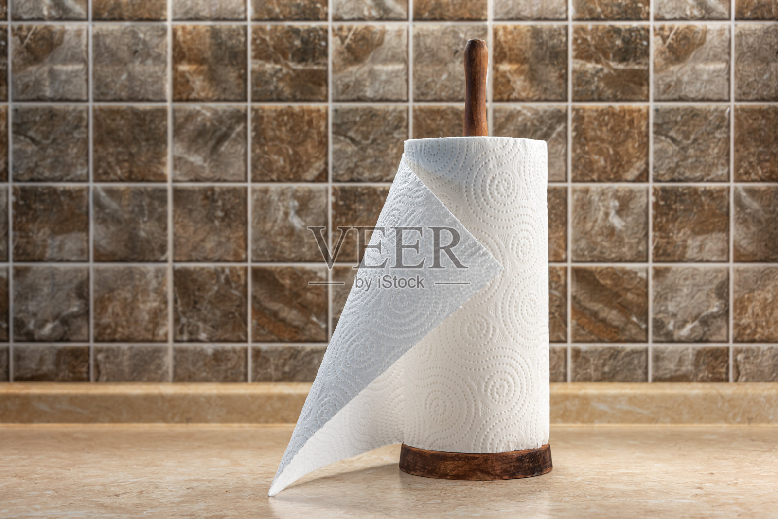 在瓷砖墙的背景下，桌子上的木制架子上放着纸巾。照片摄影图片