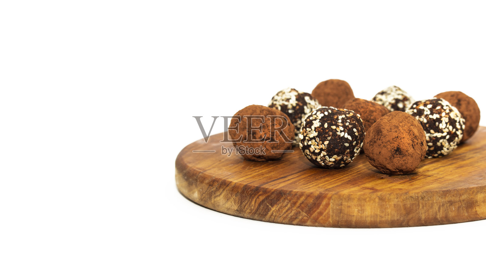 白色碗里的能量球。健康的生甜点，素食松露，枣，榛子，可可粉制成的无糖糖果。照片摄影图片