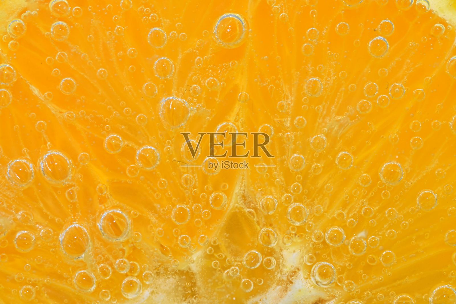 在气泡水中放一片橘子。用碳酸水泡过的橘子片。橙子切片，泡在水里。特写，微距水平图像。照片摄影图片