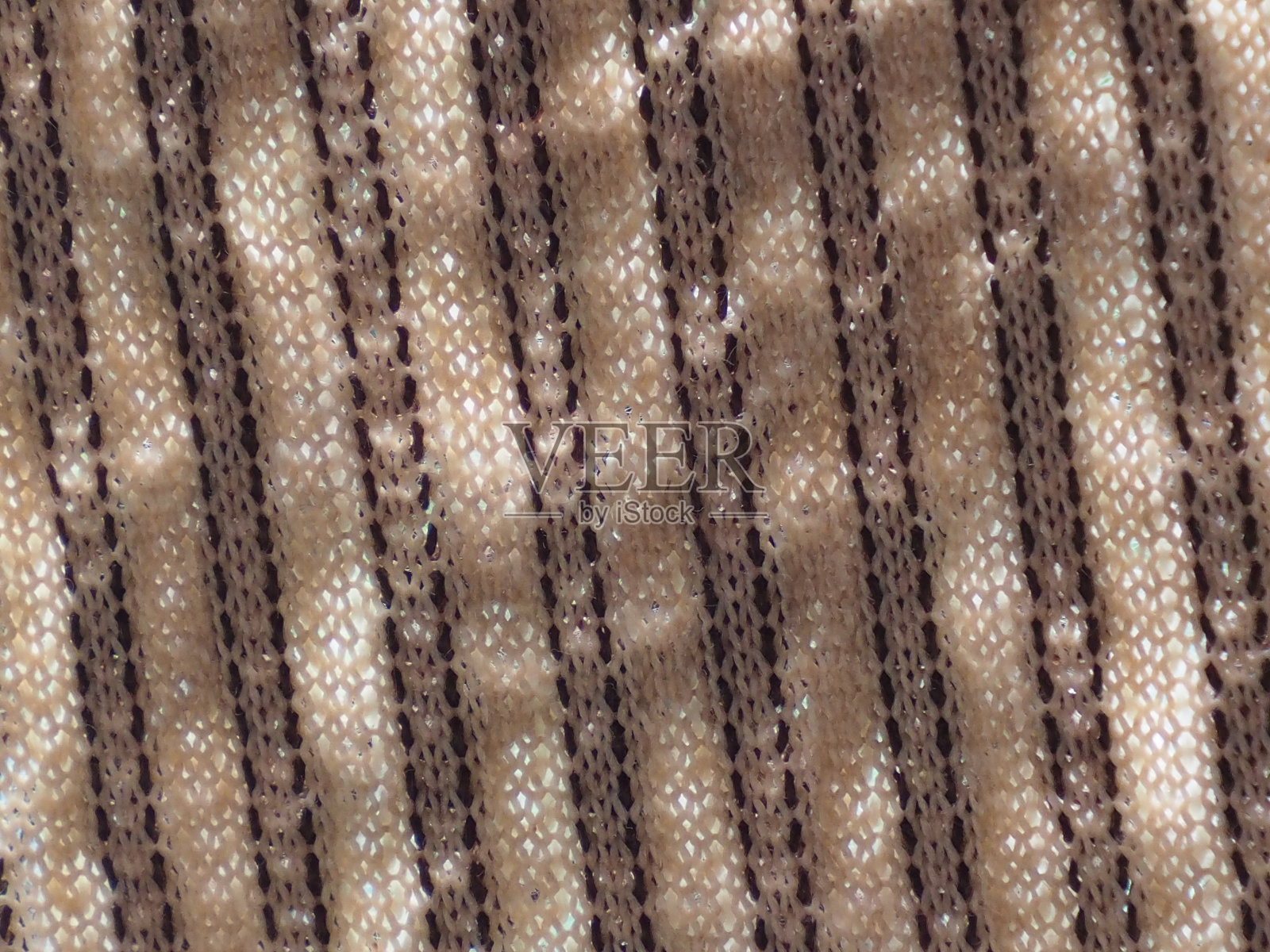 在阳光下闪闪发光的白色和棕色的织物图案。照片摄影图片