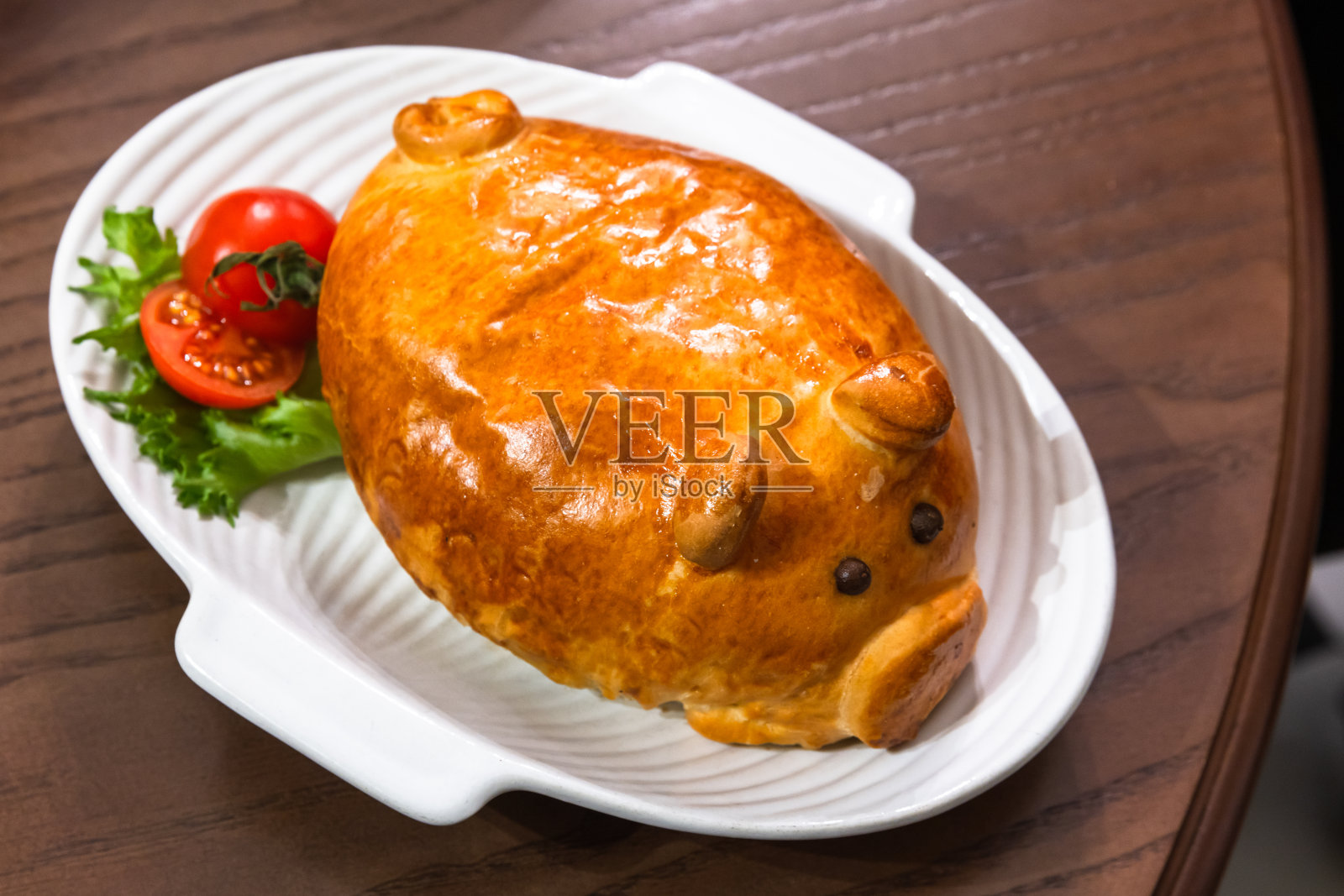 猪形肉饼放在白色盘子上，特写照片照片摄影图片