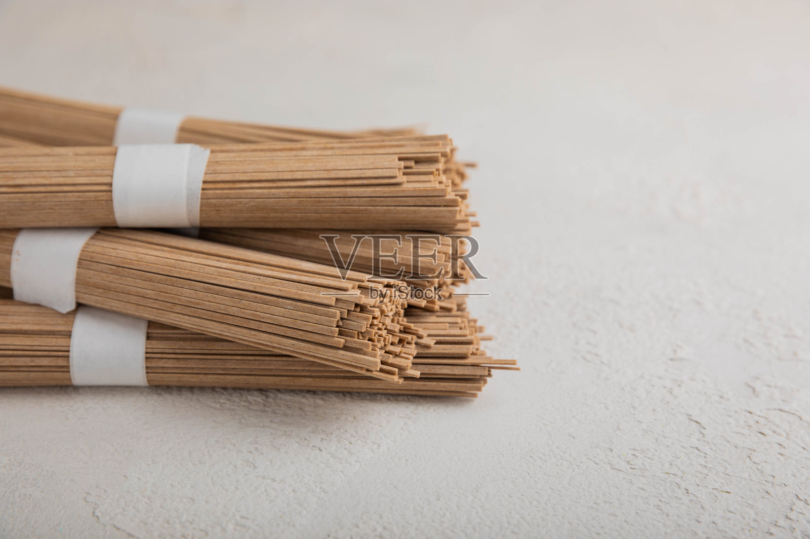 水泥背景上的荞麦糊。生面条。无麸质菜的配料。干荞麦荞麦面。传统的日本食物。健康食品。复制的地方。照片摄影图片