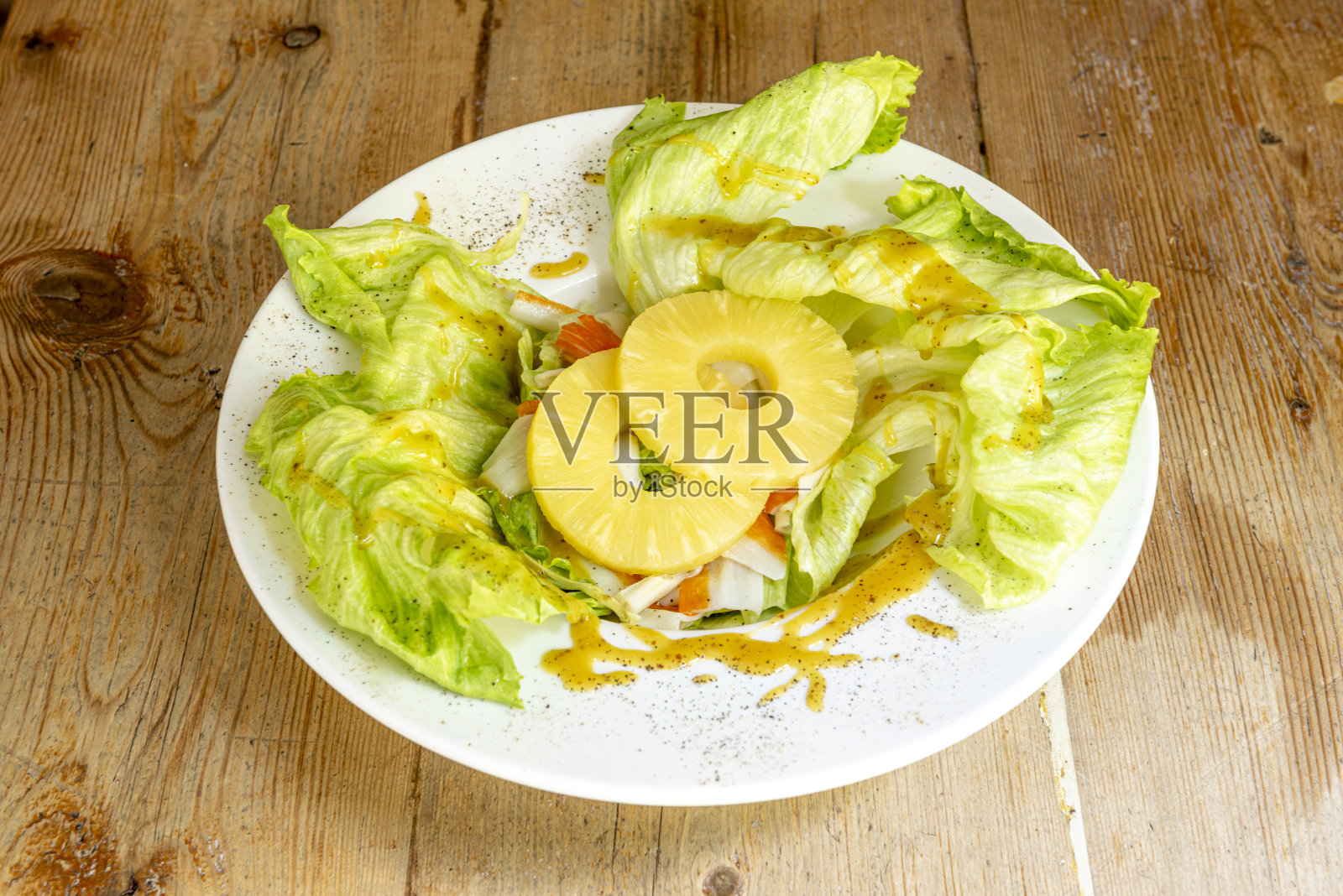 生菜和鱼糜沙拉，菠萝片和甜咖喱酱和黑胡椒照片摄影图片