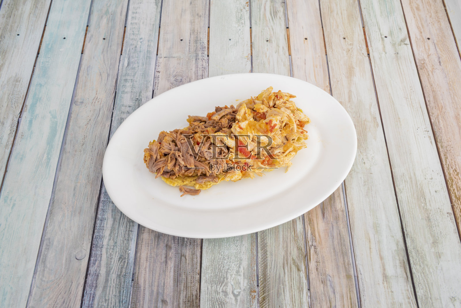 白色盘子里的委内瑞拉混合鸡肉丝和蔬菜，成熟的大蕉和牛肉丝照片摄影图片