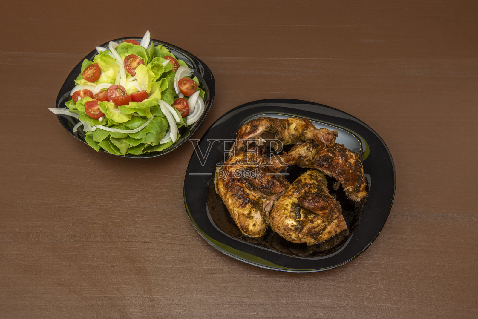 周日的菜单是木炭烤鸡和生菜沙拉，樱桃番茄和生白洋葱放在木桌上照片摄影图片