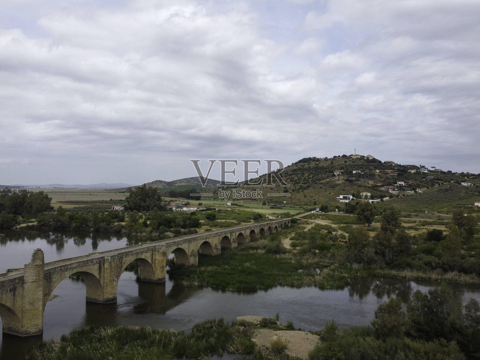 麦德林有西班牙瓜迪亚纳河上的城堡和古老的石桥，照片摄影图片