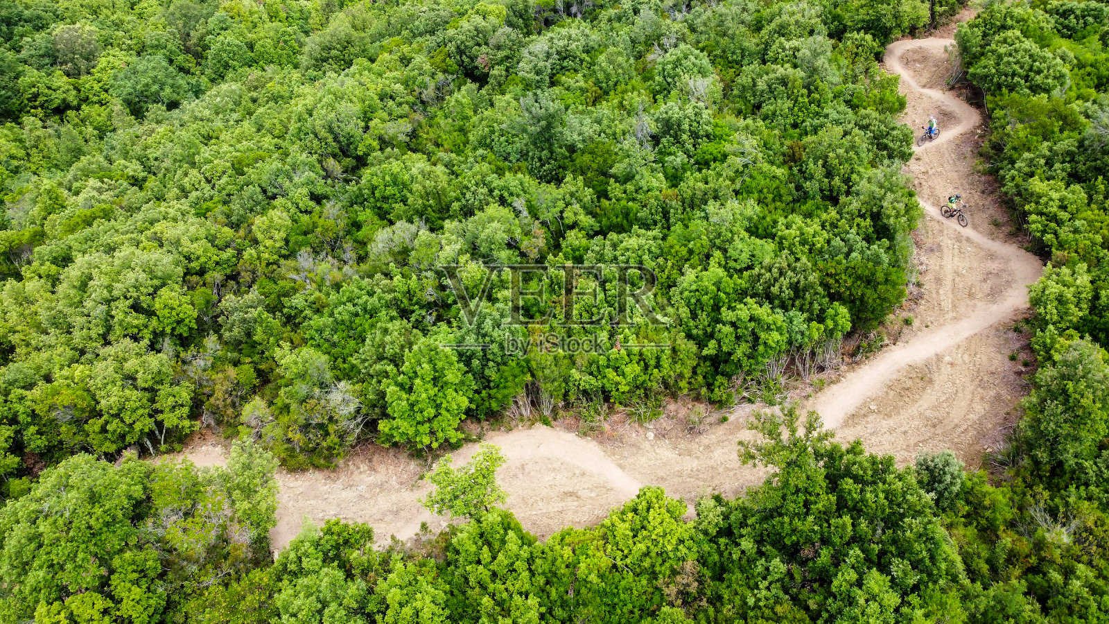 从空中俯瞰，意大利托斯卡纳马萨马里蒂玛，难以辨认的山地自行车手骑在美丽蜿蜒的单轨上照片摄影图片