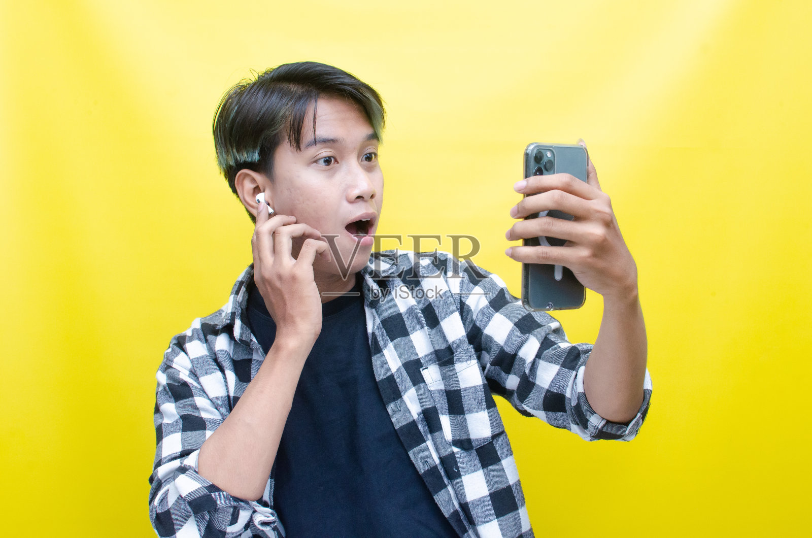 快乐的富有表现力的亚洲人使用耳机，从手机上享受音乐照片摄影图片