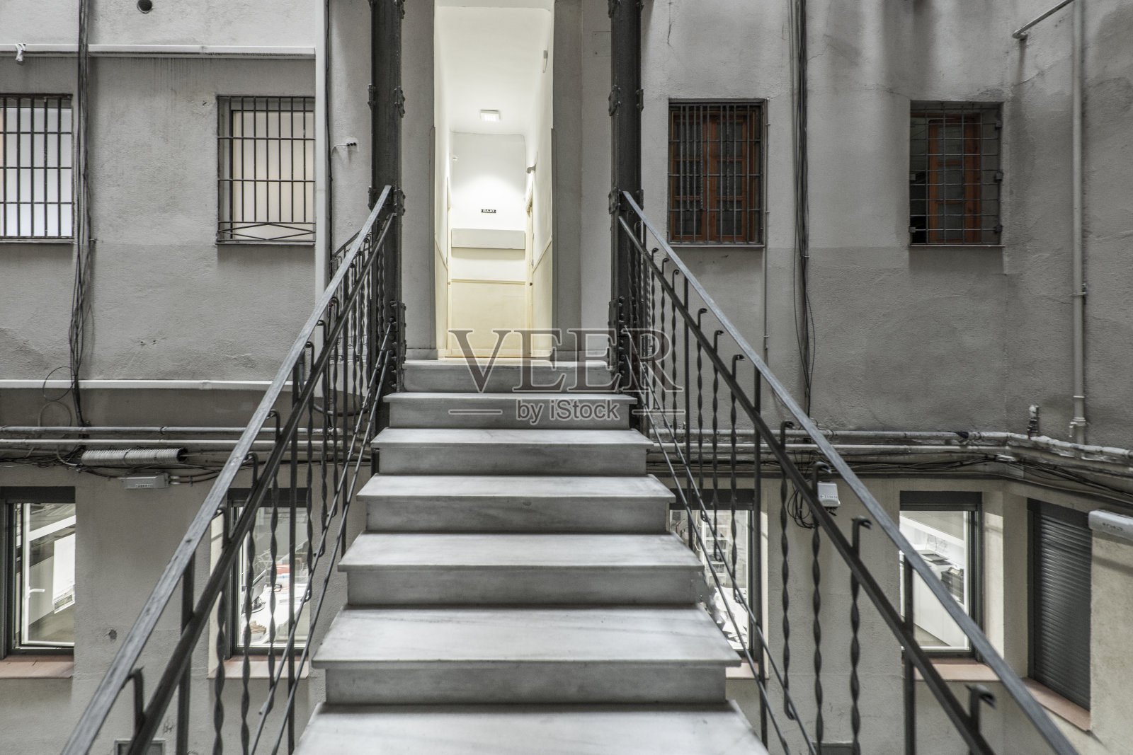 在一座古老建筑的天井里的内部楼梯的灯光照片摄影图片