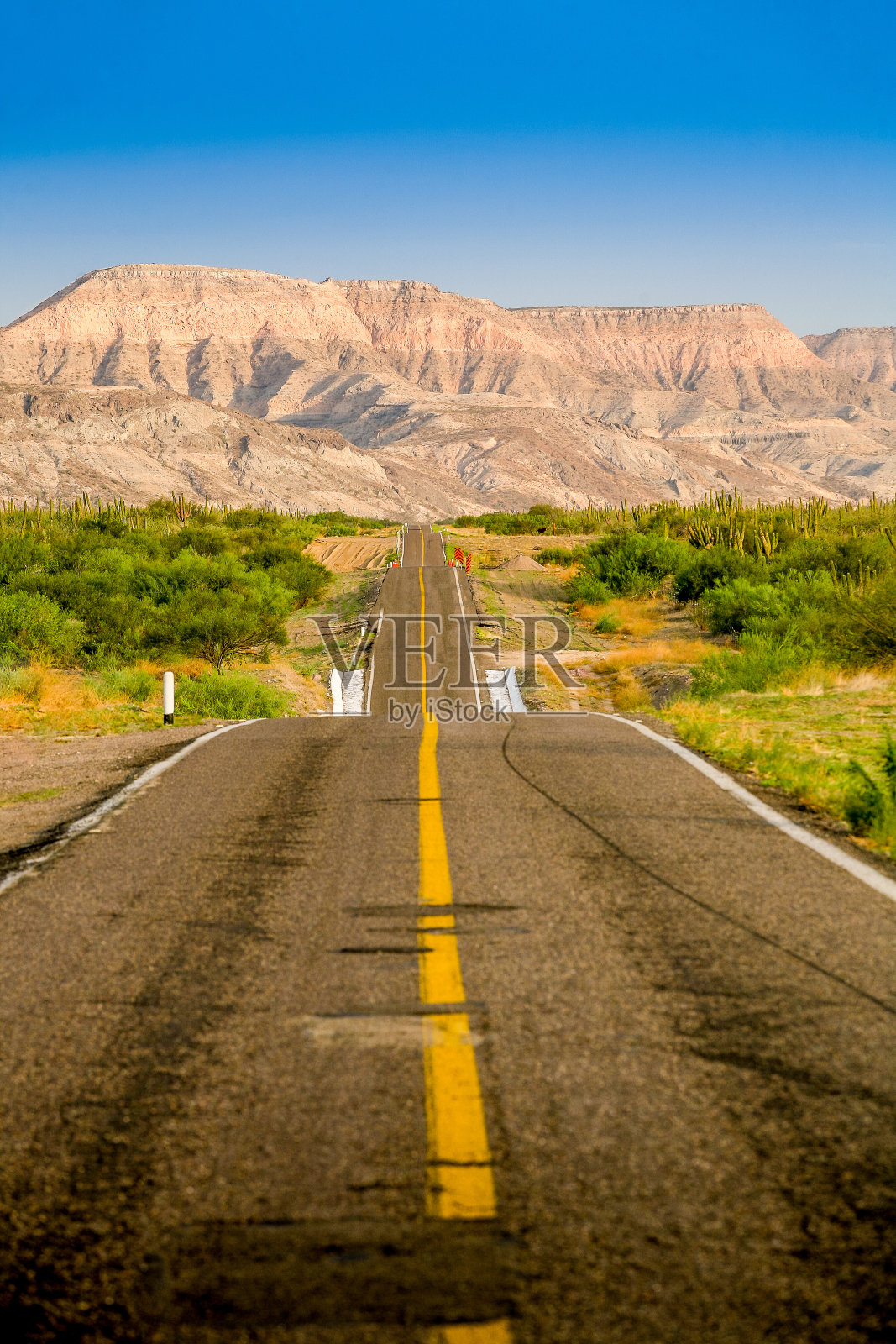 一条公路穿过下加利福尼亚的沙漠和雄伟的山区照片摄影图片
