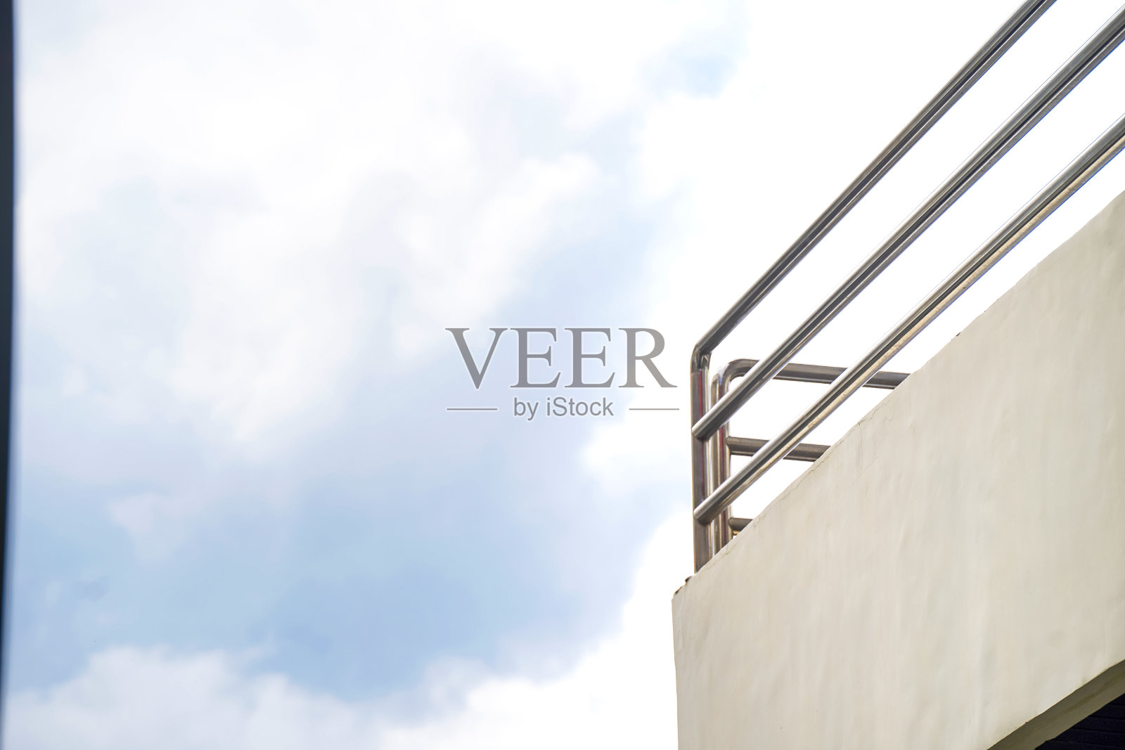 建筑二楼的栅栏，背景是多云的天空照片摄影图片