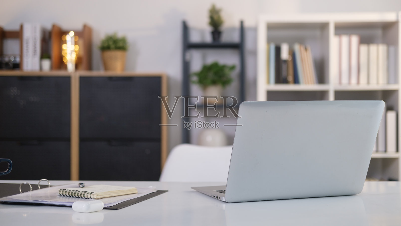 家庭办公室内部，笔记本电脑和文书在白色的桌子上。照片摄影图片