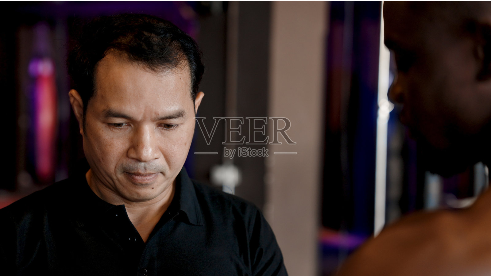 男子拳击教练，身材魁梧。准备为非洲人练习拳击包扎手指以防受伤。准备在拳击场上戴上连指手套锻炼身体，使身体强壮照片摄影图片