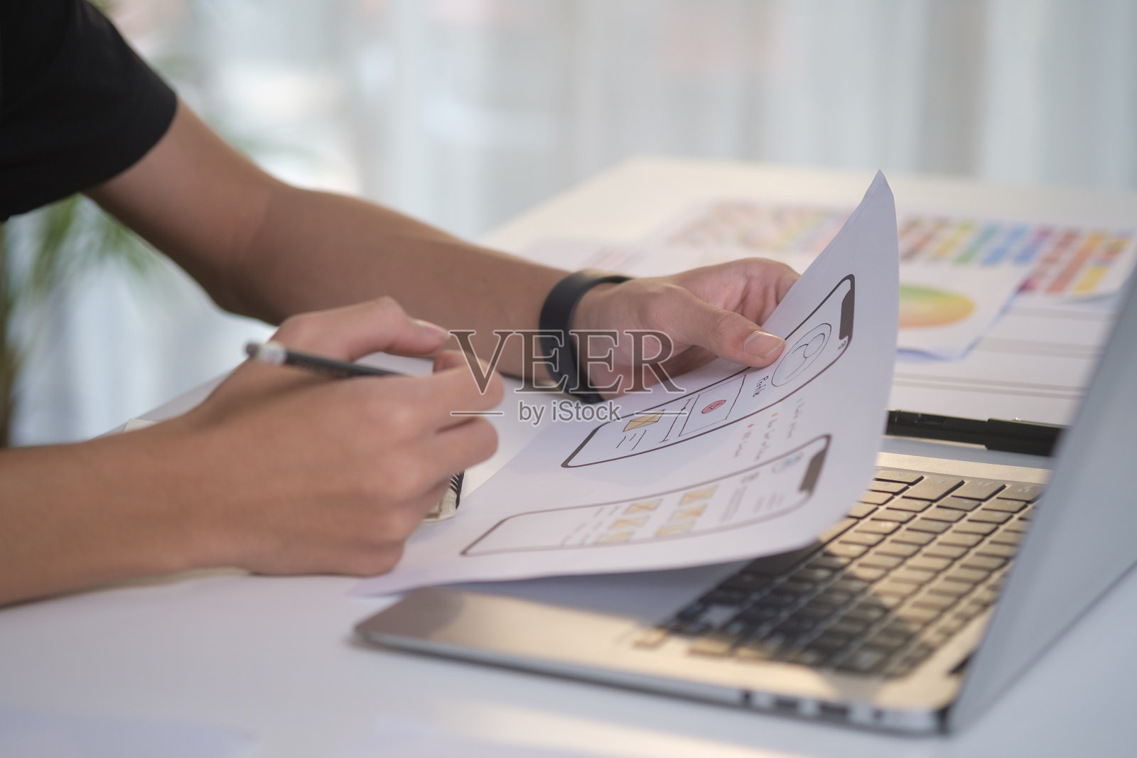 近距离ui设计器规划应用程序开发的web手机在办公桌上。照片摄影图片