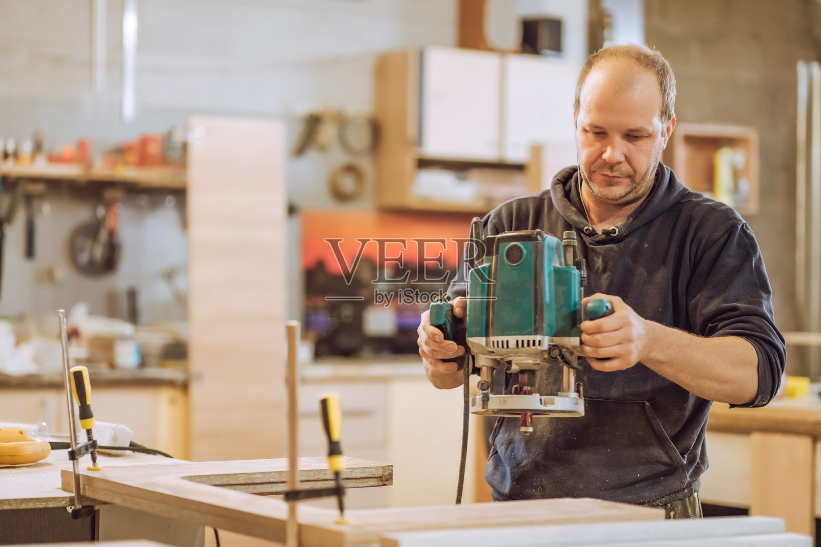 Сarpenter用电铣削、锯木板照片摄影图片