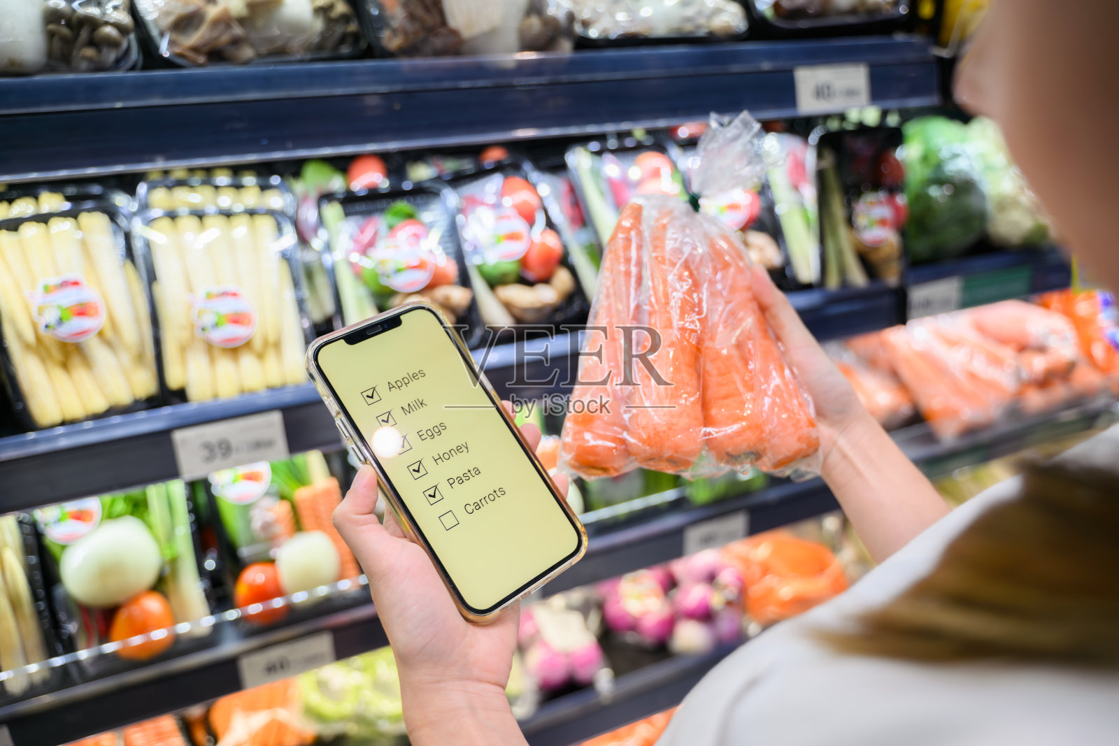 年轻成年女子在杂货店用手机照片摄影图片