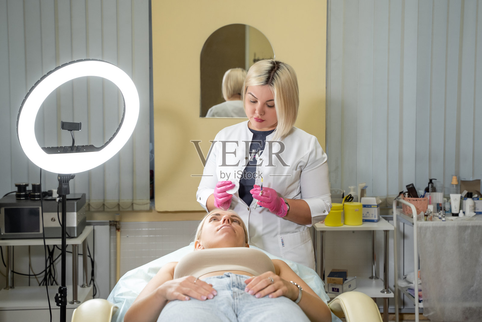 美容师持有注射器美容注射解除皮肤肿胀，吸脂生物活化美容美容程序的客户在沙龙照片摄影图片